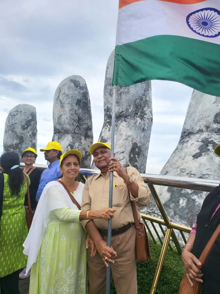 A couple with the Indian flag in front of the karst hills